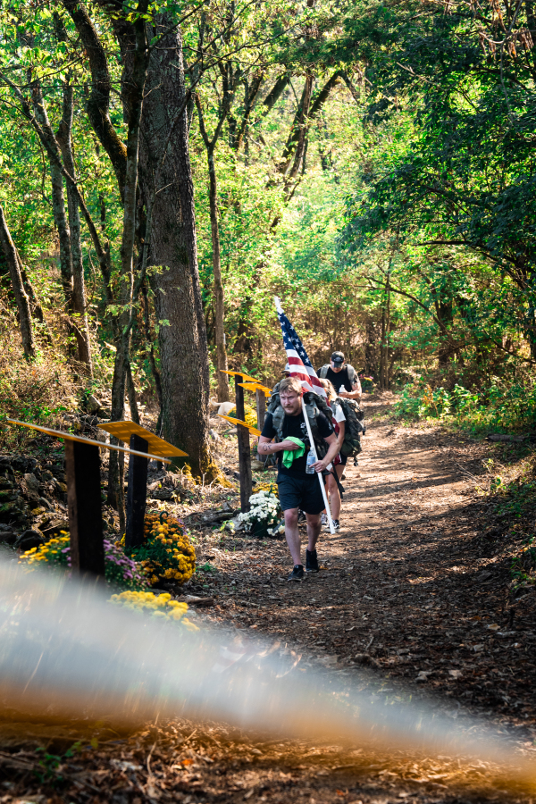 Tactical Team Rucking Past Limestone Memorials
